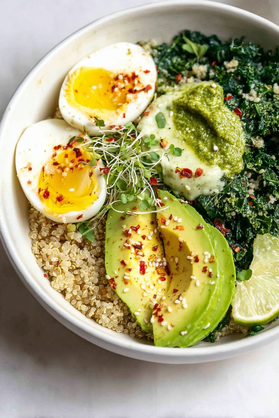 A white bowl holds a layered healthy dish set on a white marbled surface. The bottom layer is light brown quinoa, forming a grainy base. On top, bright dark green cooked kale with a slightly wet texture sits next to halved soft-boiled eggs with shiny white edges and vibrant yellow yolks. Adjacent to these is a pale green creamy dollop of pesto sauce, topped with small red chili flakes. Beside the pesto, fresh avocado slices show light green flesh with a smooth, creamy texture, sprinkled with red chili flakes and white sesame seeds. Two lime wedges with light green skin rest near the middle, adding a fresh touch. The whole dish has a slight sprinkle of microgreens and red chili bits. Photo taken with an iphone --ar 2:3 --v 7