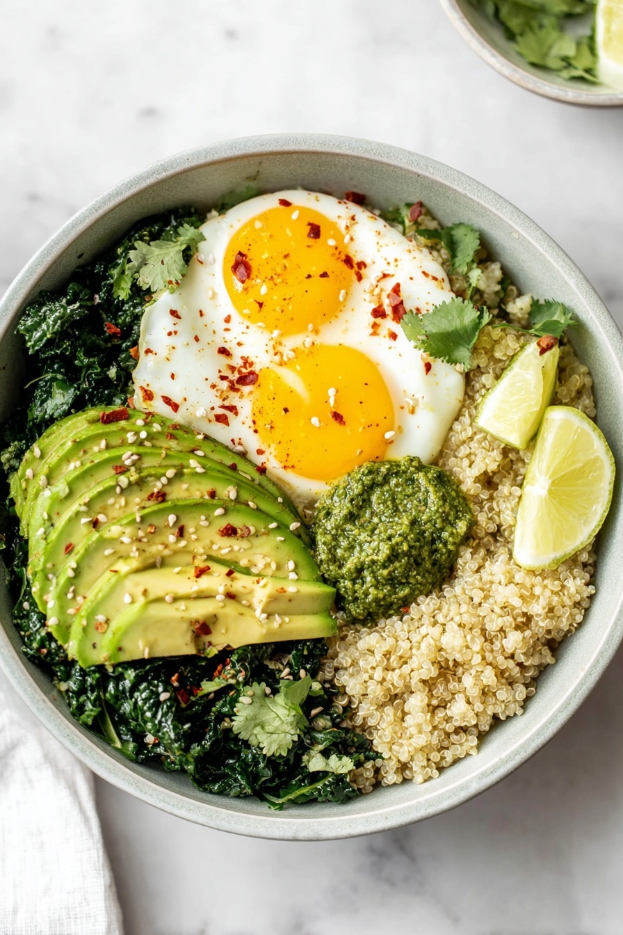 A bowl with five layers: the bottom layer is cooked quinoa with a light beige color and fluffy texture, filling about half the bowl; on one side, there are dark green sautéed kale leaves with a slightly shiny surface; next to it, three slices of bright green avocado with a smooth and creamy texture, sprinkled with small hemp seeds and red chili flakes; near the top, two fried eggs with shiny, soft white edges and bright yellow yolks sprinkled with red chili flakes; in the middle, a dollop of chunky, green pesto sauce with visible hemp seeds; two lime wedges with bright green skin and pale green inside sit beside the kale. The bowl is light gray ceramic on a white marbled surface. photo taken with an iphone --ar 2:3 --v 7