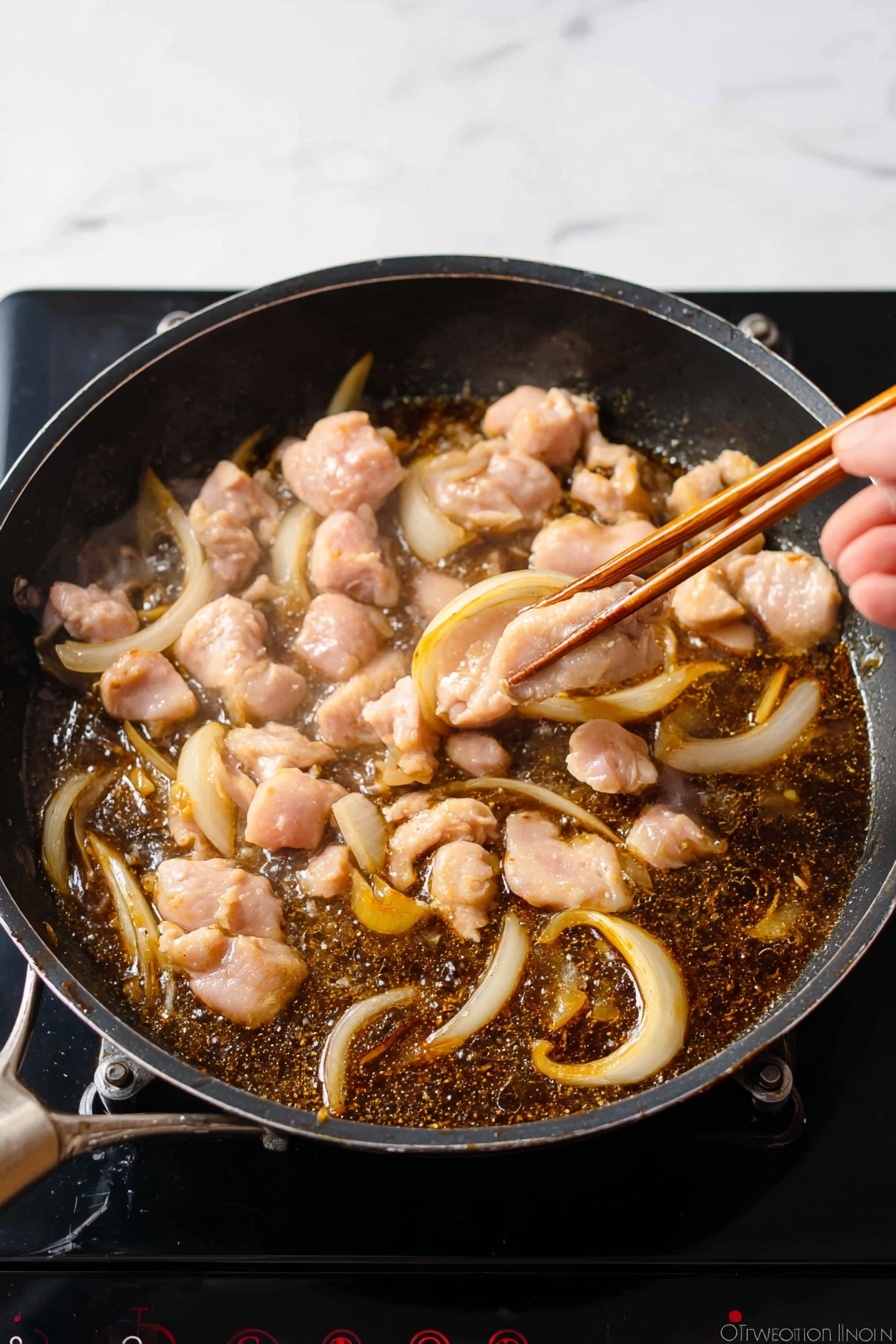 A bowl with blue vertical stripes on the outside holds a layered dish starting with chunks of light brown cooked chicken and soft, cooked onion pieces. Over these layers is a mix of smooth yellow and white scrambled eggs that cover the chicken. Fresh chopped green herbs are sprinkled on top, adding a bright green color, with a touch of red spice powder on one side. A wooden spoon rests inside the bowl on the right edge. The bowl is placed on a wooden table surface. photo taken with an iphone --ar 2:3 --v 7