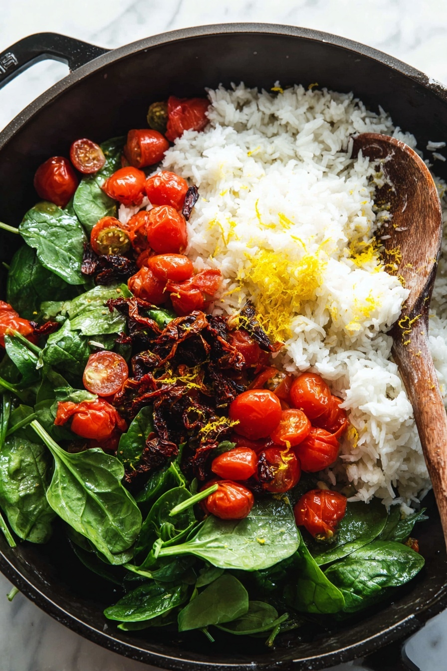 This image shows a deep black pan filled with layers of food. The bottom layer is fresh spinach leaves with a bright green color and smooth texture. Above the spinach, there are many small, red cherry tomatoes, some whole and some cut in half, showing their juicy inside. On top of the tomatoes, there is a big pile of white cooked rice with fluffy grains. Mixed in with the rice are dark brown pieces of sun-dried tomatoes and a sprinkle of bright yellow lemon zest. A wooden spoon with a rough texture rests on the right side of the pan, partially touching the food. The surface under the pan is a white marbled texture. Photo taken with an iphone --ar 2:3 --v 7