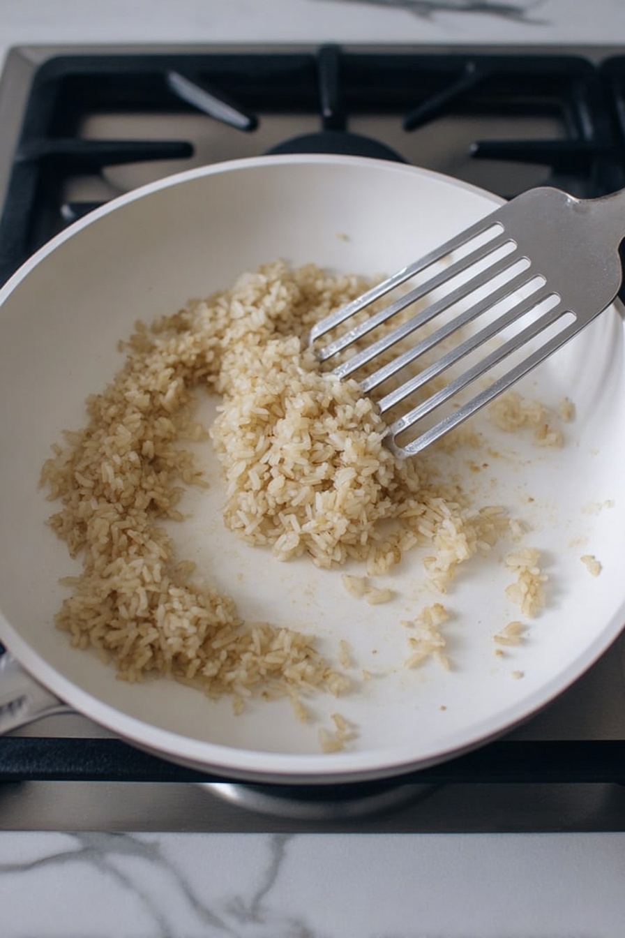 The image shows a white bowl filled with colorful food layers placed on a white marbled surface with a beige cloth underneath. The bottom layer consists of seasoned rice, topped with bright orange roasted sweet potato cubes, bright green sautéed spinach leaves, and dark red sautéed onion slices. There are also creamy green avocado chunks sprinkled with black and white sesame seeds, and a dollop of bright red kimchi. On top, a perfectly cooked half-boiled egg with a soft yellow yolk is placed, garnished with black sesame seeds and fresh green cilantro leaves. A gold fork and spoon are placed inside the bowl on the left side. Photo taken with an iphone --ar 2:3 --v 7