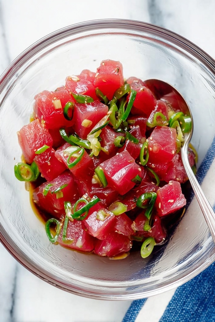 A white bowl filled with a base layer of white rice topped with four sections of ingredients: bright red diced fish mixed with herbs on the top left, small yellow mango cubes sprinkled with black seeds on the top right, beige crispy chips at the bottom left, and a mix of green edamame beans and thin cucumber slices sprinkled with black seeds at the bottom right. A few light beige pickled ginger slices are placed on the right side. The bowl sits on a white marbled surface with a pair of wooden chopsticks beside it, and soft natural light casts gentle shadows. photo taken with an iphone --ar 2:3 --v 7